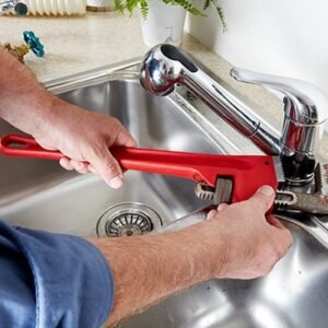 Expert Justcare technician repairing a kitchen faucet in Dubai.
